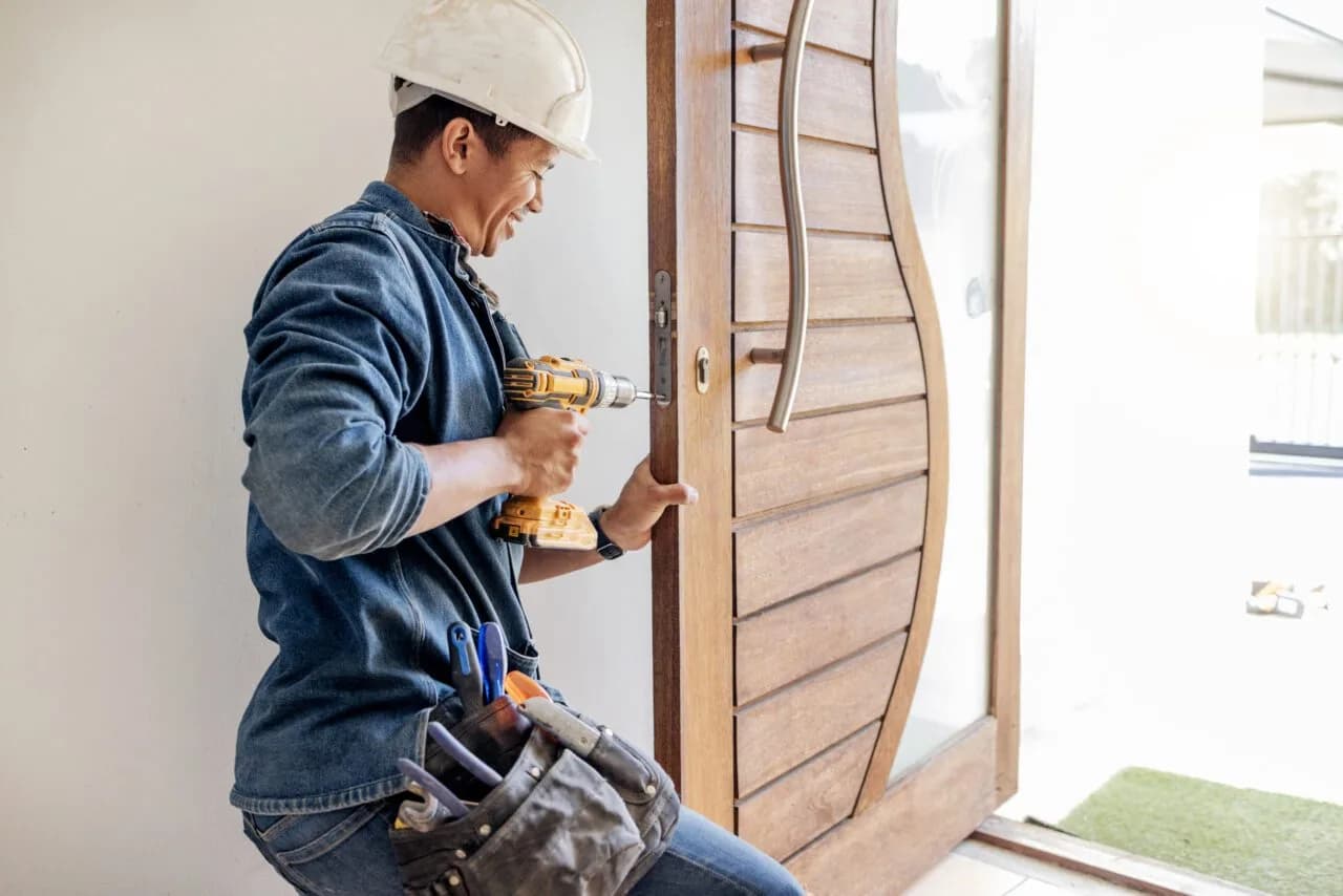 Technician fitting a lock to a commercial timber door